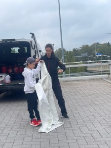 Poikaa opastetaan sammutuspeitteen käyttöön.