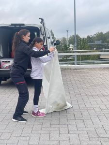 Nainen ja tyttö harjoittelee sammutuspeitteen käyttöä.