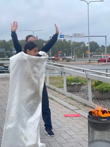 Tyttö harjoittelee sammutuspeitteen käyttöä.