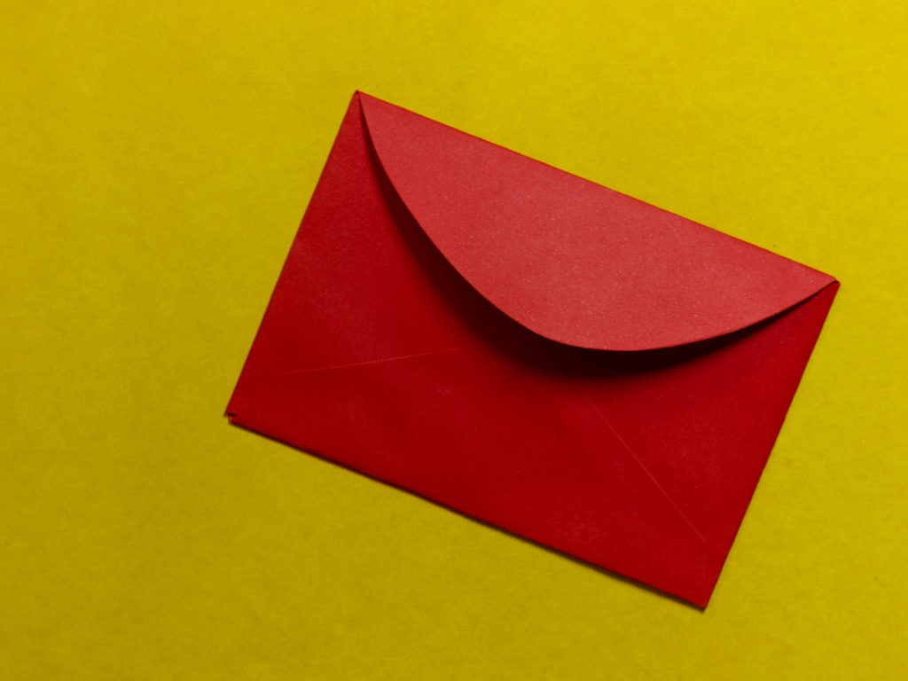 Punainen kirjekuori keltaisella taustalla
